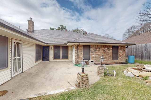 back of property with a lawn and a patio area