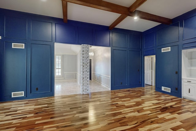 interior space with beam ceiling, light wood-type flooring, ornate columns, and coffered ceiling