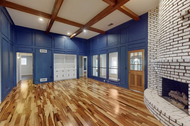 interior space featuring beam ceiling, a wealth of natural light, and light wood-type flooring