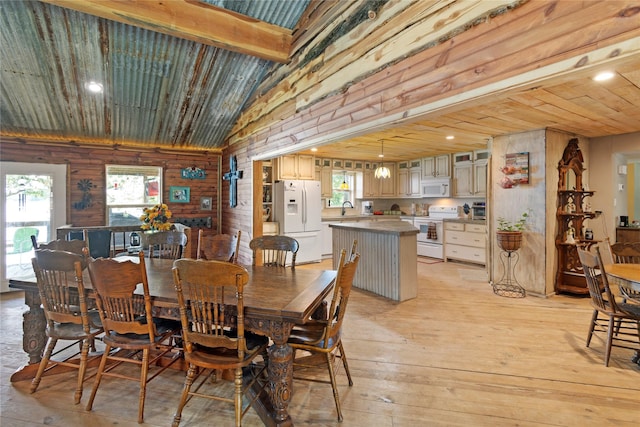 dining area with wood ceiling, sink, lofted ceiling with beams, light hardwood / wood-style floors, and wood walls