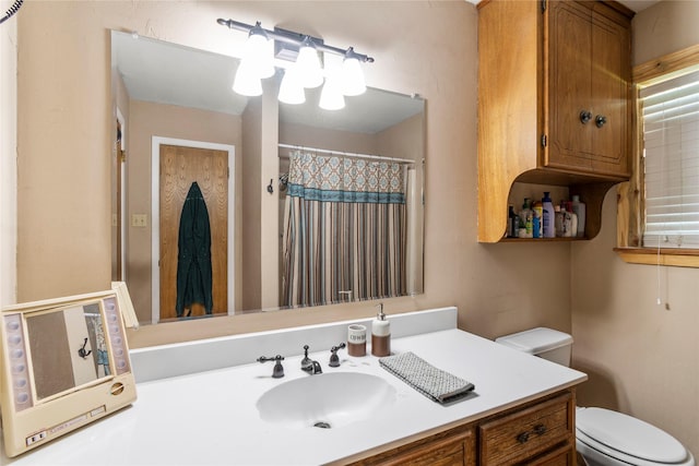 bathroom featuring a shower with curtain, vanity, and toilet