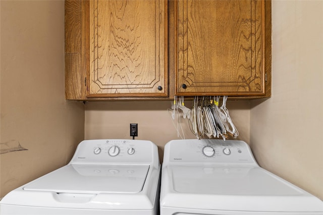 laundry room with independent washer and dryer and cabinets