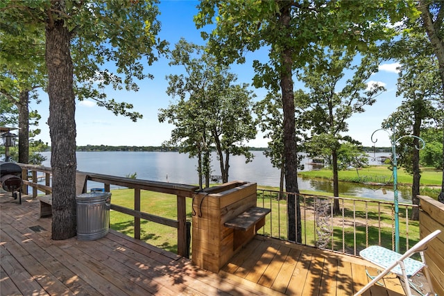 wooden deck with a lawn and a water view