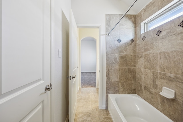 bathroom with tiled shower / bath and tile patterned flooring