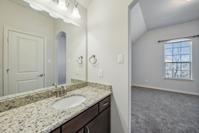 bathroom with vanity and vaulted ceiling