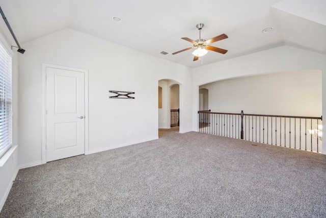 empty room featuring lofted ceiling, ceiling fan, and carpet flooring