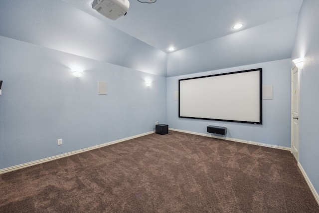 home theater featuring dark colored carpet and vaulted ceiling