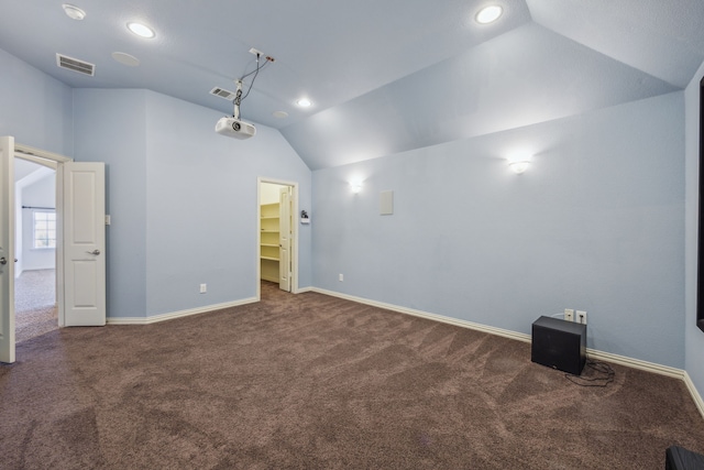 interior space with vaulted ceiling and dark carpet