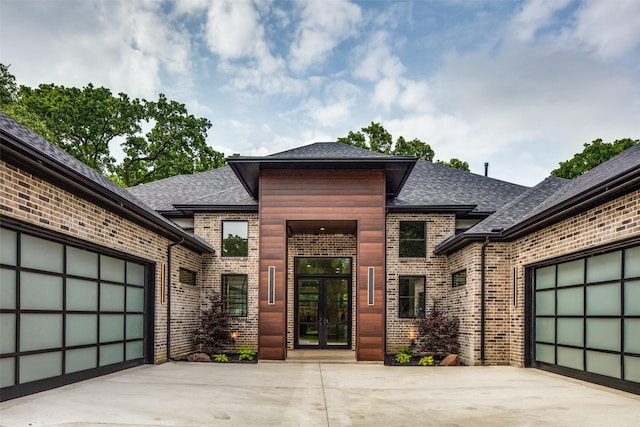 entrance to property with concrete driveway, an attached garage, and brick siding