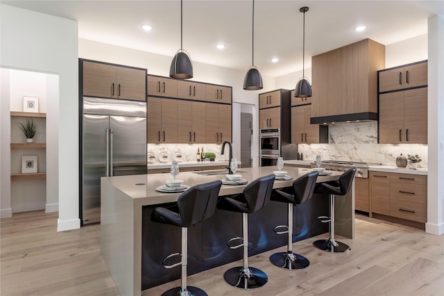 kitchen with a breakfast bar area, modern cabinets, appliances with stainless steel finishes, and a sink