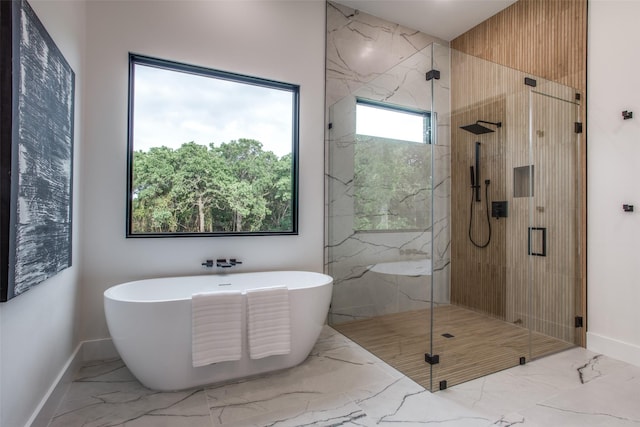 full bathroom with marble finish floor, a freestanding bath, and a shower stall