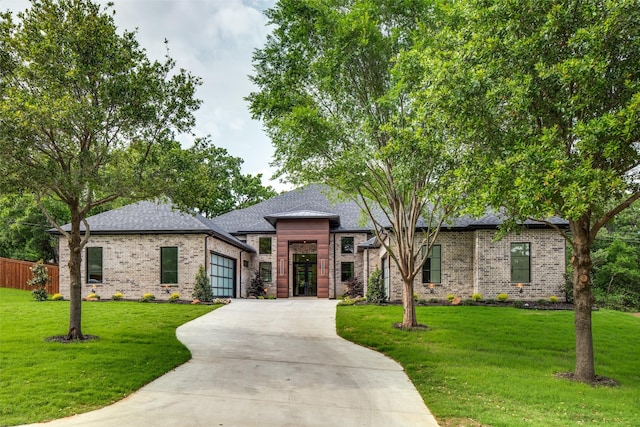 view of front of home featuring a garage, brick siding, concrete driveway, and a front yard