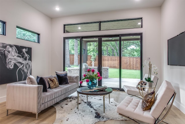 living area featuring a wealth of natural light, recessed lighting, and light wood-type flooring