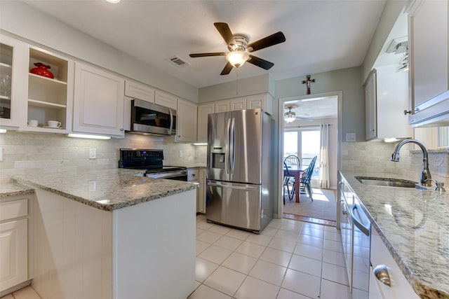 kitchen featuring appliances with stainless steel finishes, light stone countertops, sink, and white cabinets