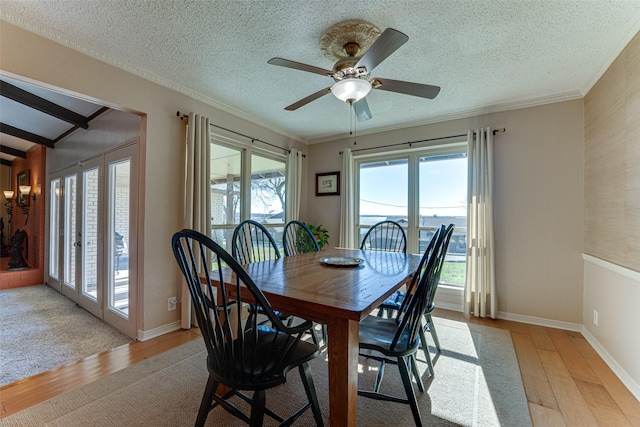 dining space with french doors, a textured ceiling, light wood-type flooring, ornamental molding, and ceiling fan