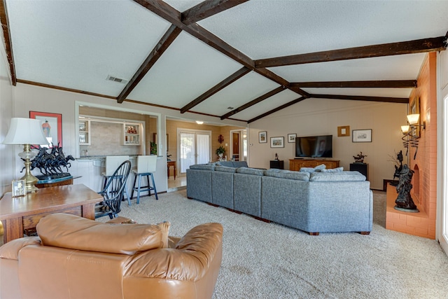 carpeted living room featuring lofted ceiling with beams and a textured ceiling