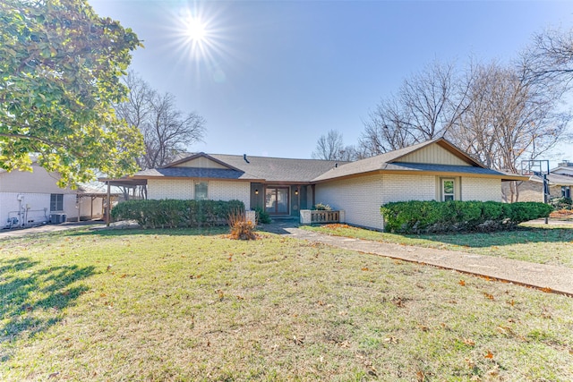 ranch-style house with a front yard and central AC unit