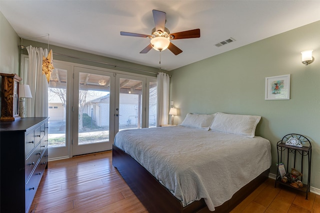 bedroom featuring wood-type flooring, access to outside, ceiling fan, and french doors