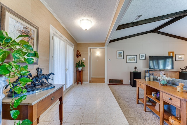 foyer entrance featuring ornamental molding, vaulted ceiling with beams, and a textured ceiling