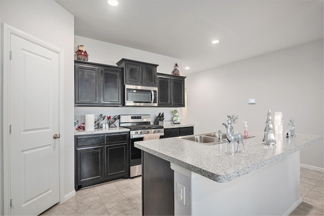 kitchen with a kitchen island with sink, sink, and stainless steel appliances