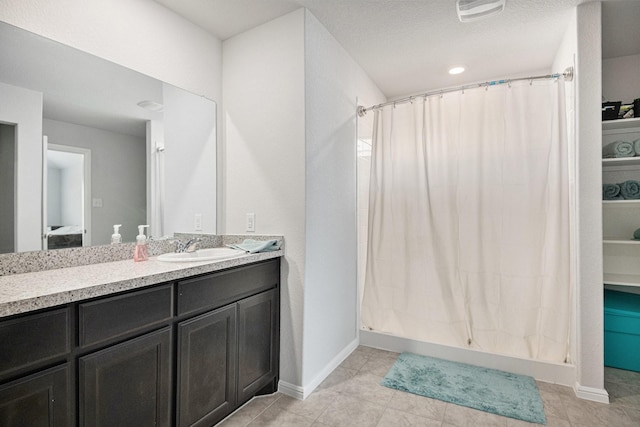 bathroom featuring a shower with curtain, vanity, and a textured ceiling