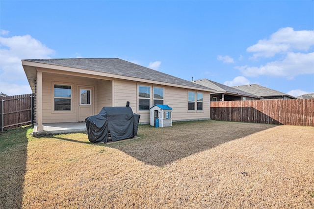 back of house with a lawn and a patio