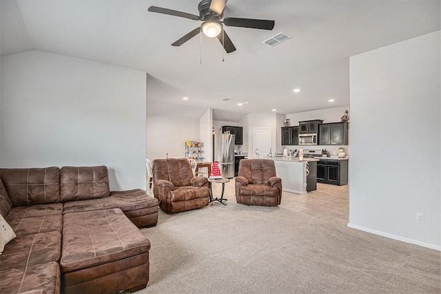 living room with ceiling fan, lofted ceiling, and carpet flooring