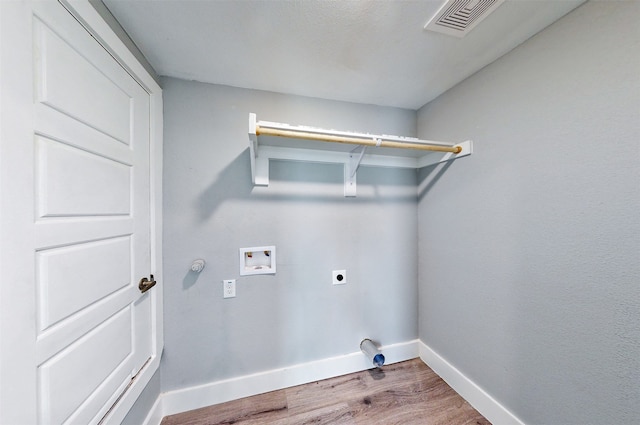 laundry area featuring washer hookup, hookup for an electric dryer, gas dryer hookup, and wood-type flooring