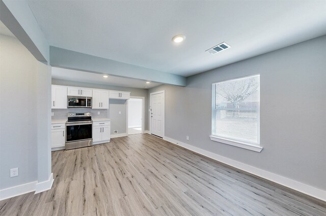 kitchen with white cabinetry, light hardwood / wood-style flooring, and stainless steel appliances