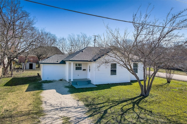 rear view of house with a lawn and a storage shed