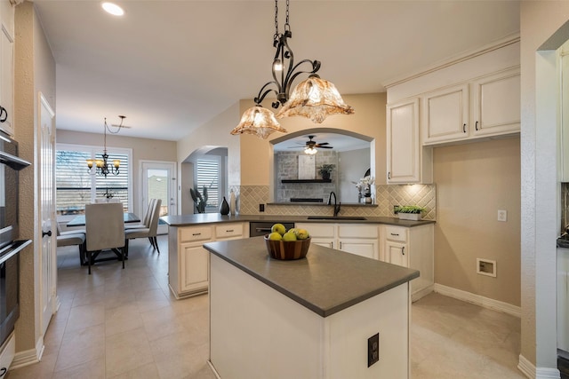 kitchen featuring tasteful backsplash, sink, pendant lighting, and kitchen peninsula