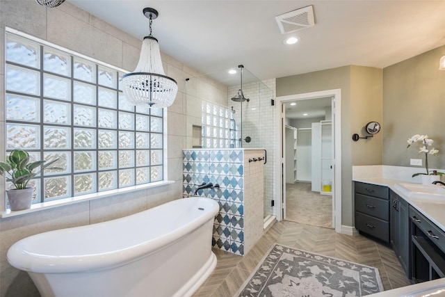 bathroom with parquet flooring, vanity, and shower with separate bathtub