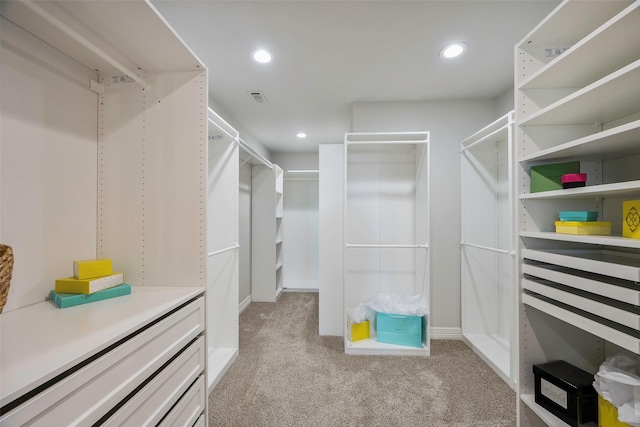 walk in closet featuring light colored carpet