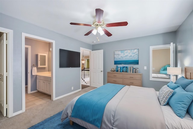 bedroom featuring connected bathroom, light colored carpet, and ceiling fan