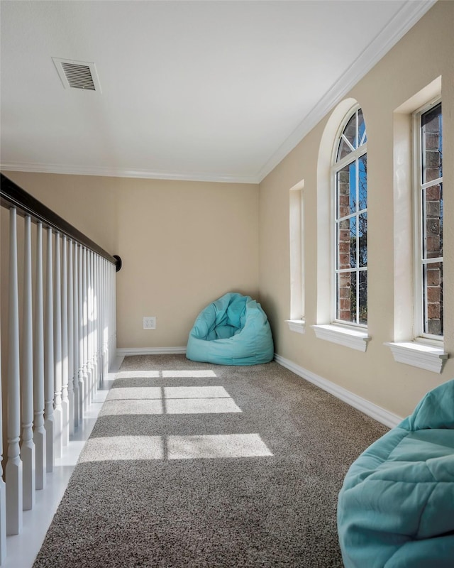 sitting room with ornamental molding and carpet floors