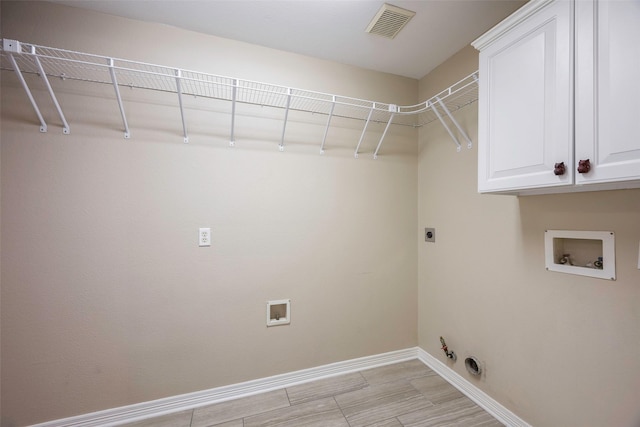 clothes washing area with gas dryer hookup, cabinets, hookup for a washing machine, and electric dryer hookup