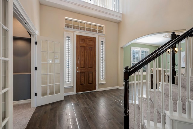 foyer featuring french doors, a towering ceiling, and dark hardwood / wood-style flooring