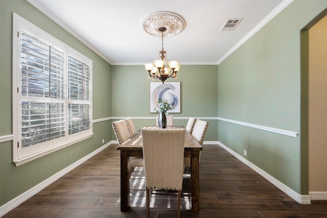 dining area with an inviting chandelier, ornamental molding, and dark hardwood / wood-style floors