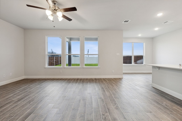 empty room with hardwood / wood-style floors and ceiling fan