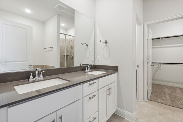 bathroom featuring vanity, tile patterned floors, and a shower with door