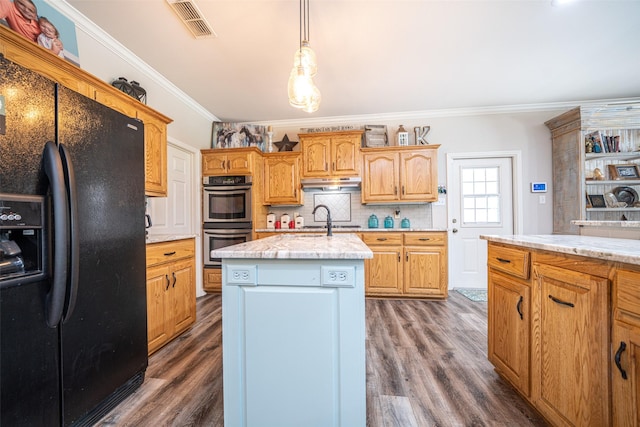 kitchen with black fridge, crown molding, a center island with sink, dark hardwood / wood-style floors, and stainless steel double oven