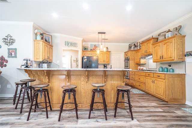 kitchen featuring backsplash, a kitchen bar, black fridge with ice dispenser, kitchen peninsula, and light wood-type flooring