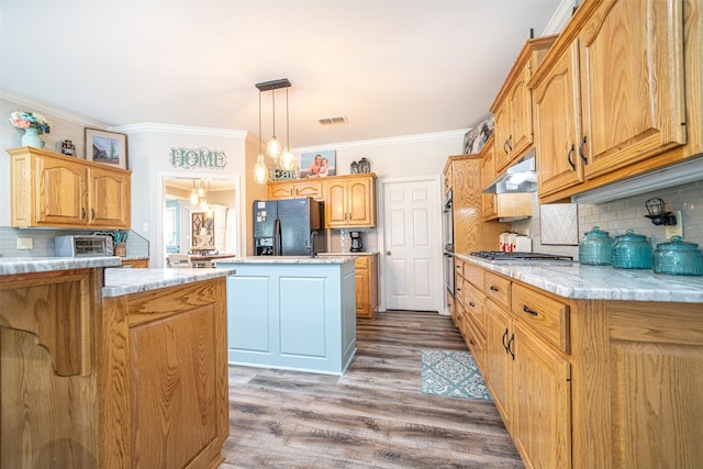 kitchen with stainless steel appliances, decorative light fixtures, a center island, and light stone countertops