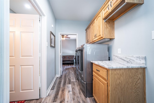 clothes washing area with washer and dryer, dark hardwood / wood-style flooring, cabinets, and ceiling fan