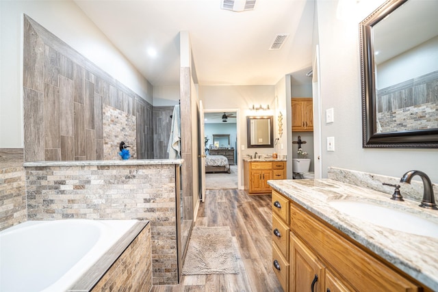 bathroom featuring vanity, hardwood / wood-style flooring, shower with separate bathtub, and ceiling fan