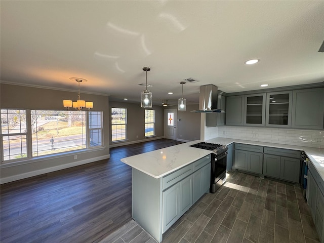 kitchen with pendant lighting, tasteful backsplash, extractor fan, light stone countertops, and gas stove