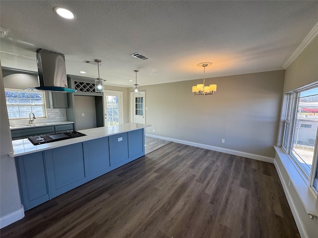 kitchen with island range hood, pendant lighting, black stovetop, tasteful backsplash, and dark hardwood / wood-style flooring