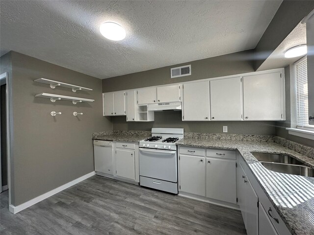 kitchen with a textured ceiling, white appliances, sink, white cabinets, and dark hardwood / wood-style floors