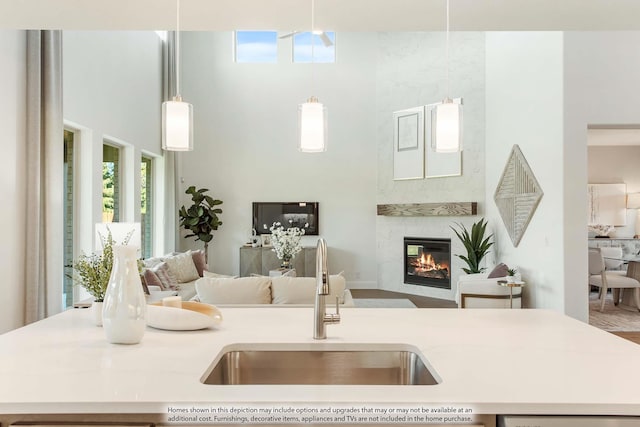 kitchen featuring decorative light fixtures, a large fireplace, and sink