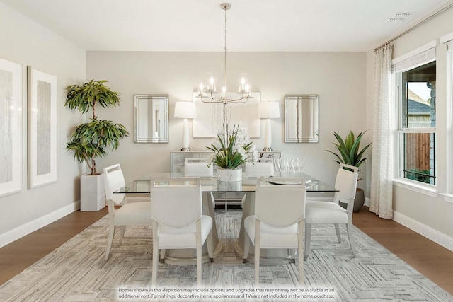 dining space with a chandelier and light hardwood / wood-style floors